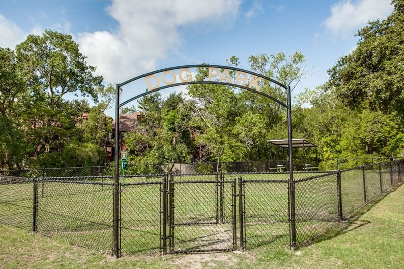 a fenced in park with a gate and a sign at The Tribeca On  Creek